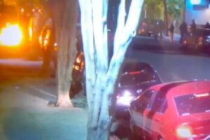 Grupo de encapuzados, à direira, ataca a entrada da sede do jornal Clarín, o maior da Argentina, com bombas incendiárias Foto: Reprodução