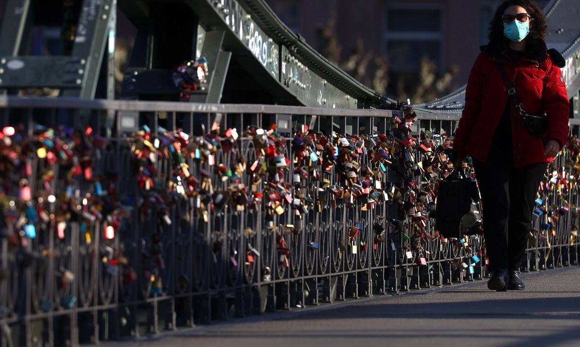 Mulher anda mascarada em ruas de Berlim