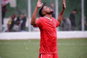 Anderson Lourenço ajoelhado em jogo de futebol