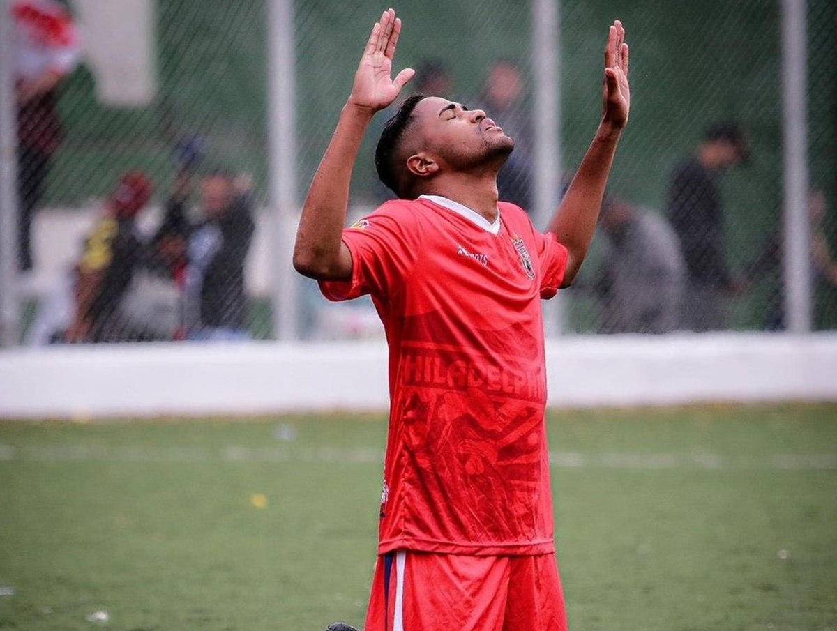 Anderson Lourenço ajoelhado em jogo de futebol