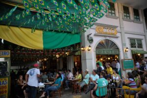 Mais da metade dos maiores de 18 anos consomem bebidas alcoólicas - pessoas bebem na calçada durante jogo do Brasil