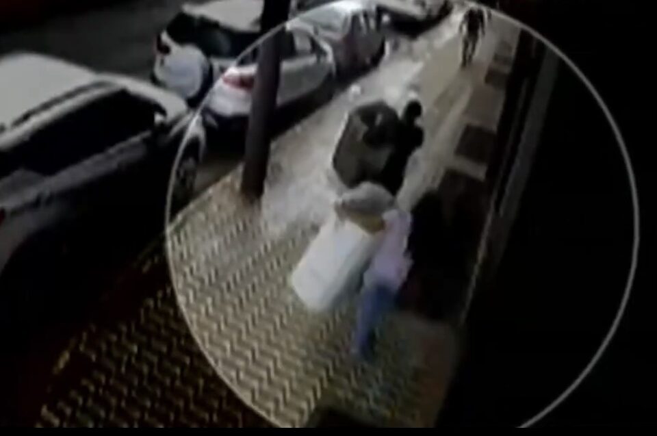 Mulheres andando pela calçada com os tanquinhos nos braços.
