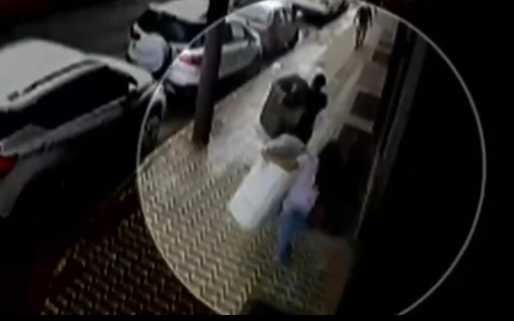 Suspeitas passam pela calçada carregando os tanquinhos nos braços. Foto: Captura de vídeo. 