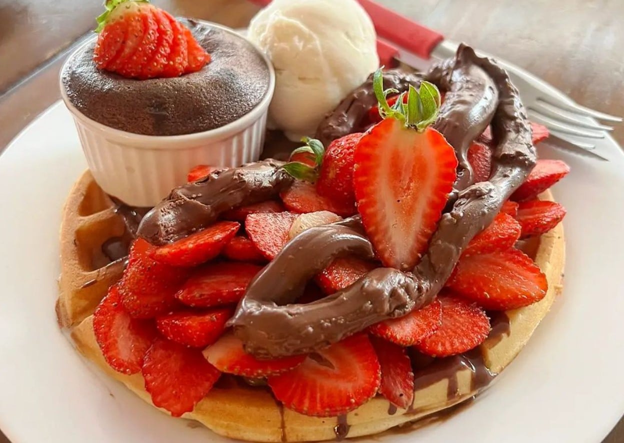 Waffle com morango, chocolate, uma bola de sorvete de creme e um bolinho petit gateau, da Cia do Chocolate, opção para comer waffles em Goiânia