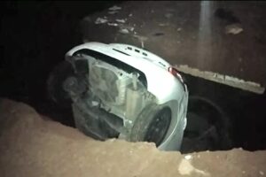 Carro fica praticamente submerso em buraco no meio da rua Barão de Mesquita, em Aparecida (Foto: Reprodução - ArquivoPessoal)