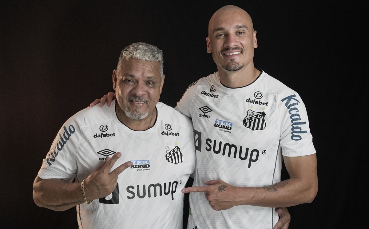Maicon vestido com a camisa do Santos ao lado de seu pai, Maurídes