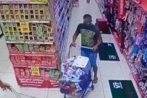 Homem foi filmado enchendo um carrinho de supermercado antes de levar os produtos sem pagar nada (Foto: Reprodução - Tv Anhanguera)