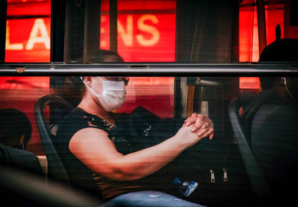 Usuários de transporte coletivo usando máscara