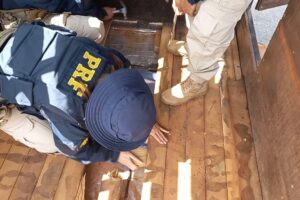 PRF apreendendo droga escondida em assoalho de carro