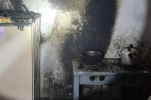 Policiais resgatam mulher de incêndio que começou na cozinha de casa, em Catalão (Foto: Bombeiros)