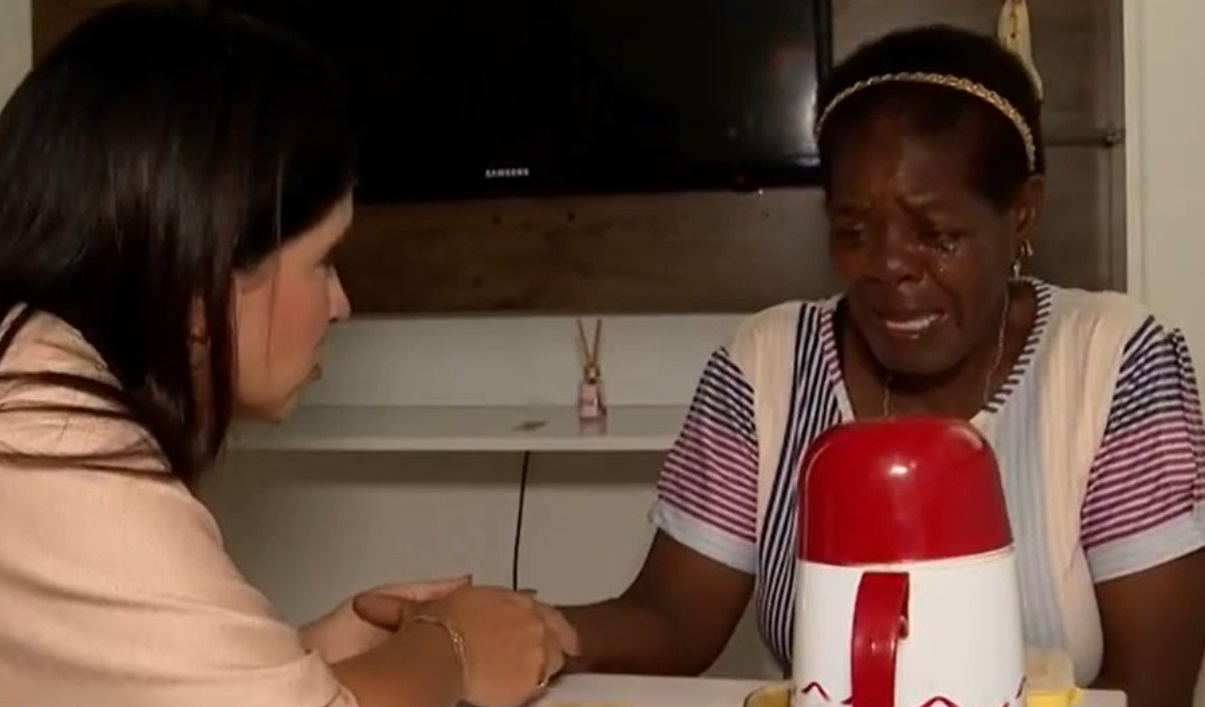 Doméstica medo de segurar mão de repórter branca. Ex-patroa de Madalena da Silva diz que não pagava salário porque a considerava "da família"