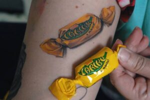 Marca também produziu vídeo para homenagear a consumidora nas redes sociais. Mulher tatua bombom Caribe e ganha 10 kg de chocolate da Garoto