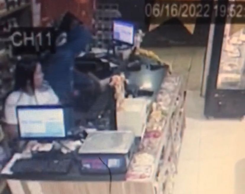 Um dos criminosos recolheu o dinheiro do caixa (Foto: Captura)