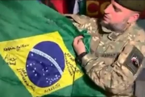 Combatente checheno exibe bandeira que pertencia a brasileiro morto na Ucrânia (Foto: Reprodução)