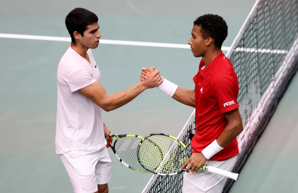 Carlos Alcaraz cumprimenta Felix Auger-Aliassime após vitória do canadense na Copa Davis. Foto: Clive Brunskill - Getty Images