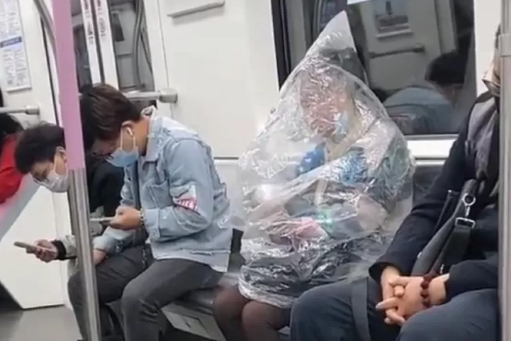 Mulher se cobre com saco plástico para comer banana no metrô na China