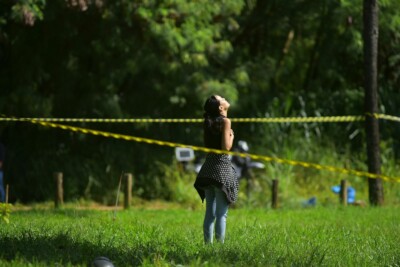 Namorada busca refúgio em orações para além do cordão de isolamento dos Bombeiros, após confirmação da morte de Warley (Foto: Jucimar de Sousa/Mais Goiás)