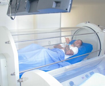 Vinicius deitado dentro da câmara hiperbárica