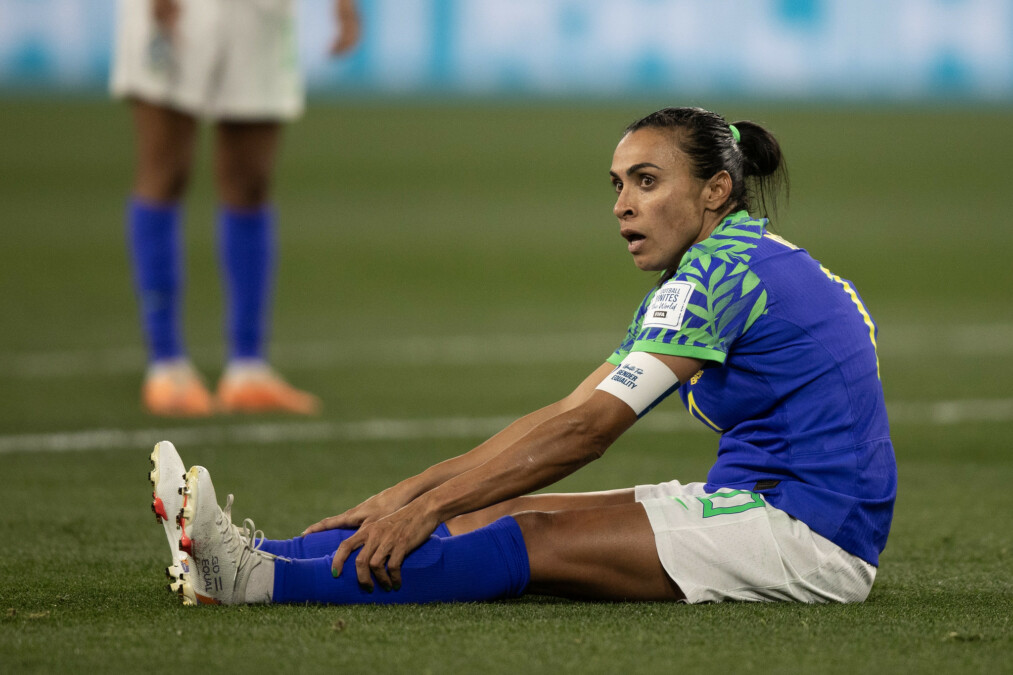 Marta sentada no gramado durante jogo contra a Jamaica