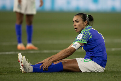 Marta sentada no gramado durante jogo contra a Jamaica