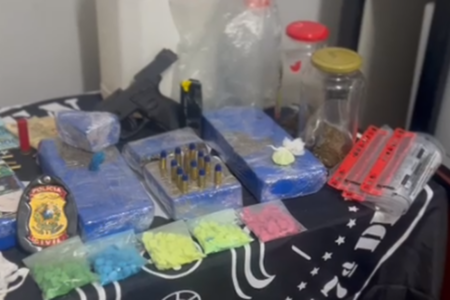 Entorpecentes apreendidos durante operação contra tráfico de drogas em Alexânia. A imagem mostra diversas drogas apreendidas em cima de uma mesa com a logo da Polícia Civil de Goiás