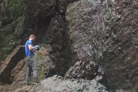 Agente faz perícia em local que homem morreu após cair de cachoeira em Morrinhos.