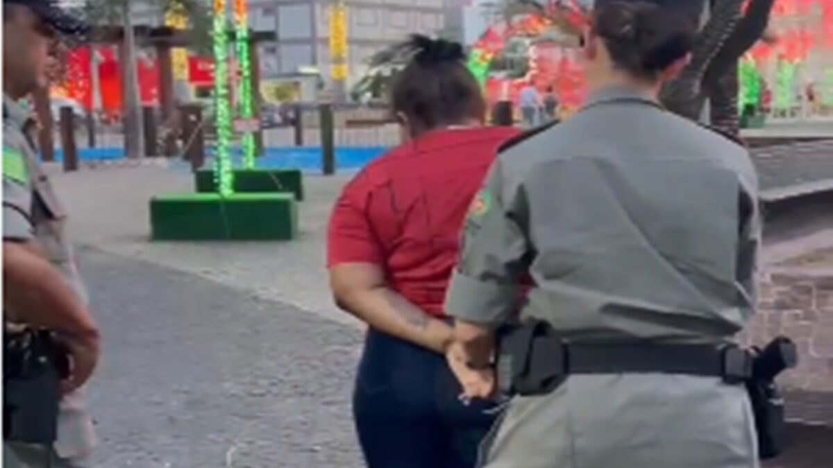 Mulher suspeita de tráfico de drogas em Caldas Novas aparece sendo conduzida por uma policial militar.