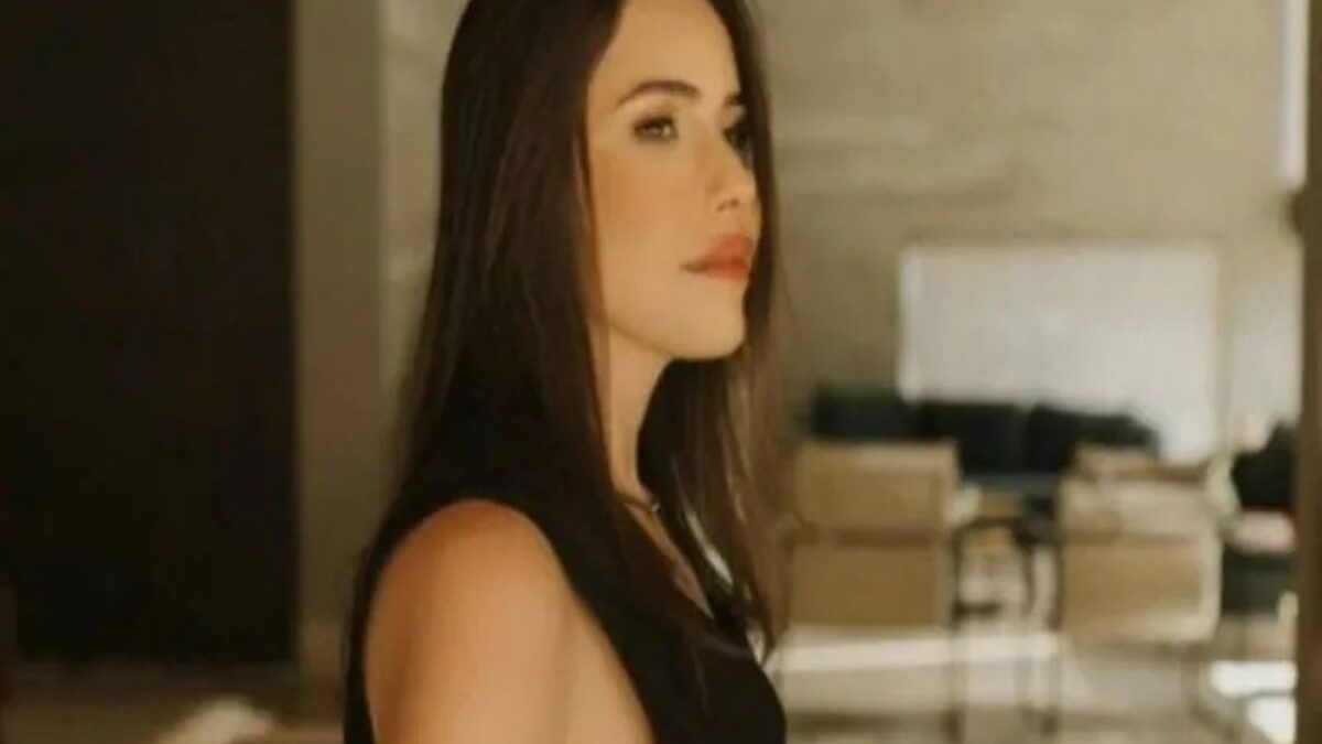 Amanda Partata, suspeita de matar o ex-sogro e a mãe dele, aparece olhando para o lado. No fundo, há objetos, como cadeiras.