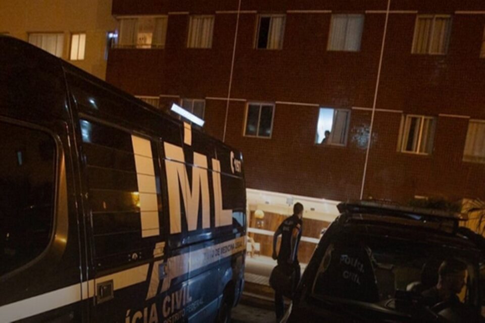 Imagem mostra carro do IML nas proximidades do apartamento em que a idosa matou o filho com autismo a tiros, no DF.