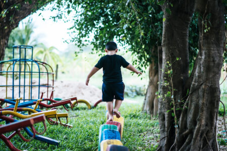 Criança se equilibra em playground de condomínio - veja como garantir a segurança de crianças em condomínios (Foto: reprodução/Freepik)