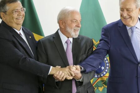 Flávio Dino, Lula e Ricardo Lewandowski de mãos unidas em anúcio de que de que Ricardo assumirá o Ministério da Justiça (Foto: Marcello Carmargo/Agência Brasil)