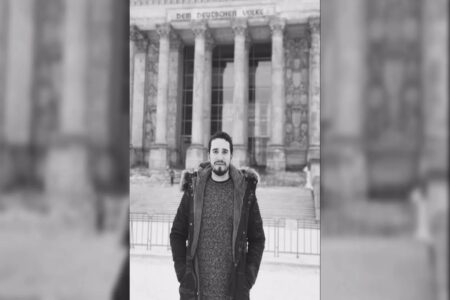 Empresário de Goiás que morreu após se afogar em Alagoas aparece em pé, com as mãos nos bolsos, em frente a um monumento.