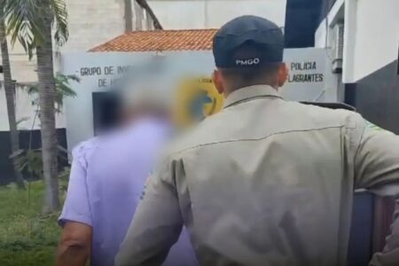 Dono de mercearia suspeito de estupro contra adolescente em Caldas Novas é conduzido para a delegacia por um policial militar.