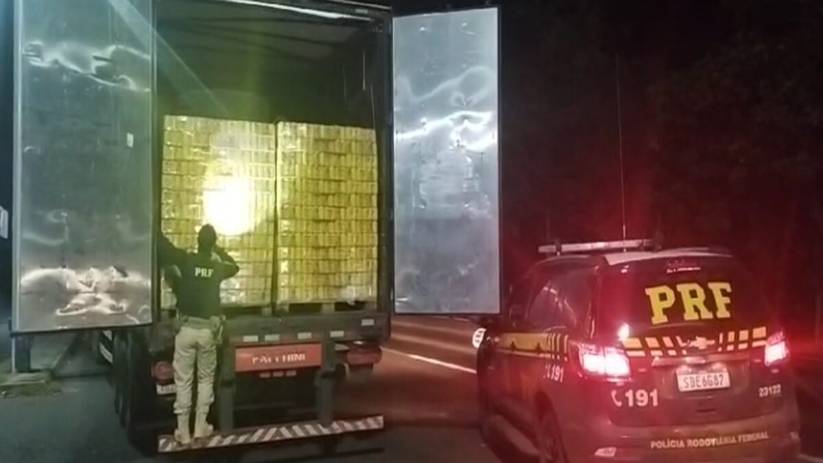 Imagem mostra um policial fiscalizando a carga de cerveja que estava sem nota fiscal.