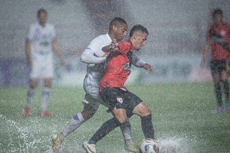 Gabriel Baralhas sendo marcado durante jogo na chuva