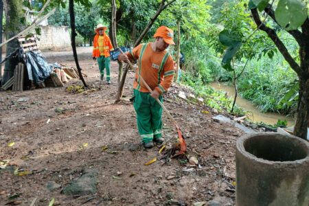 Agente de limpeza da Comurg trabalha ao lado do Rio Meia Ponte (Foto: Comurg)
