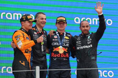 Verstappen comemorando no pódio ao lado de Norris, Hamilton e um membro da Red Bull