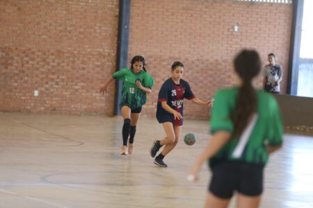 Jovens disputando handebol feminino