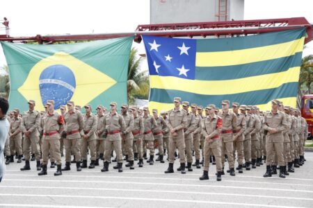 Bombeiros convocado posam para foto diante das bandeiras de Goiás e do Brasil