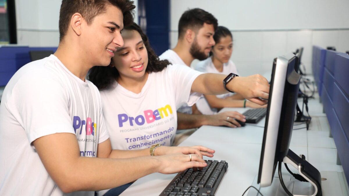 Imagem colorida mostra pessoas mexendo no computador.