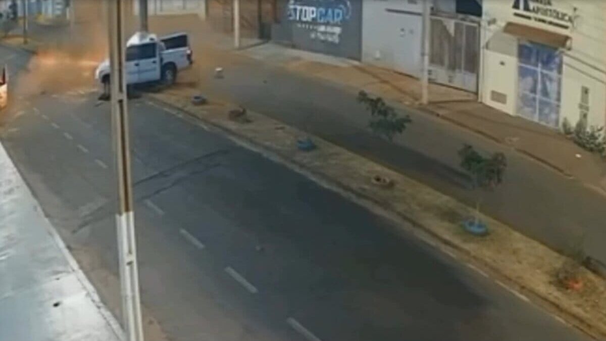 Imagem colorida mostra uma avenida na cidade de Itumbiara. Ao fundo, uma caminhonete branca batendo em um poste.