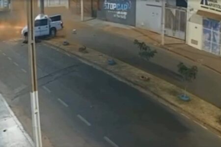 Imagem colorida mostra uma avenida na cidade de Itumbiara. Ao fundo, uma caminhonete branca batendo em um poste.
