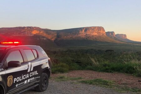 Imagem colorida mostra uma viatura da Polícia Civil parada em um morro