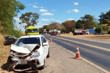 Imagem colorida mostra um carro branco com a frente amassada após um acidente de trânsito.