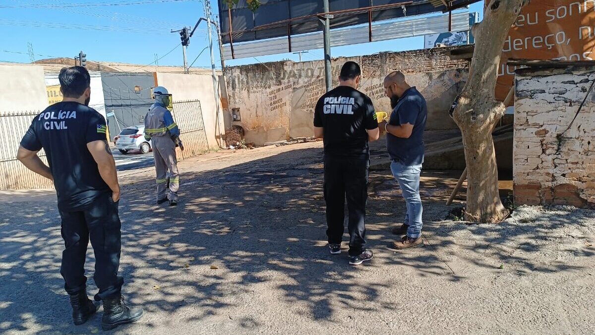 Imagem colorida mostra um agente da Polícia Civil conversando com um homem dentro de um laa jato