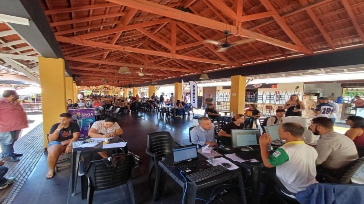 Imagem colorida mostra um local com várias pessoas em um feirão de empregos