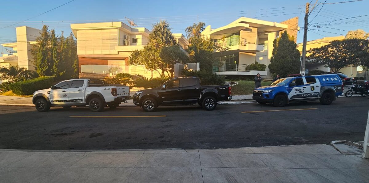 Viaturas da PM e do MP diante da casa de investigados em operação contra fraudes em licitações em Senador Canedo