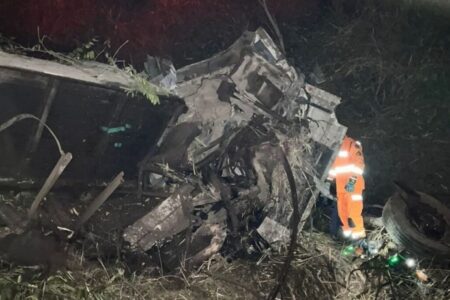 Imagem colorida mostra a cabine de um caminhão destruída após o veiculo capotar em uma rodovia.