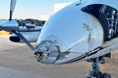 Imagem colorida mostra o bico de um avião danificado após um acidente