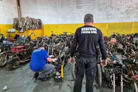 Imagem colorida mostra agentes da Polícia Civil dentro de uma loja de motos